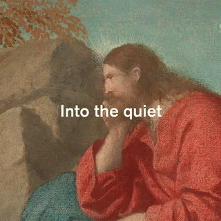 A man in a red robe sits pensively against a rocky background under a blue sky, with "Into the quiet" text, evoking solitude and contemplation.