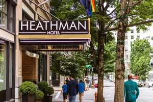 The Heathman Hotel exterior awning with flags and people walking by on the street outside